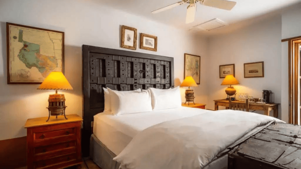 acequia king room with historical map and antique bedframe