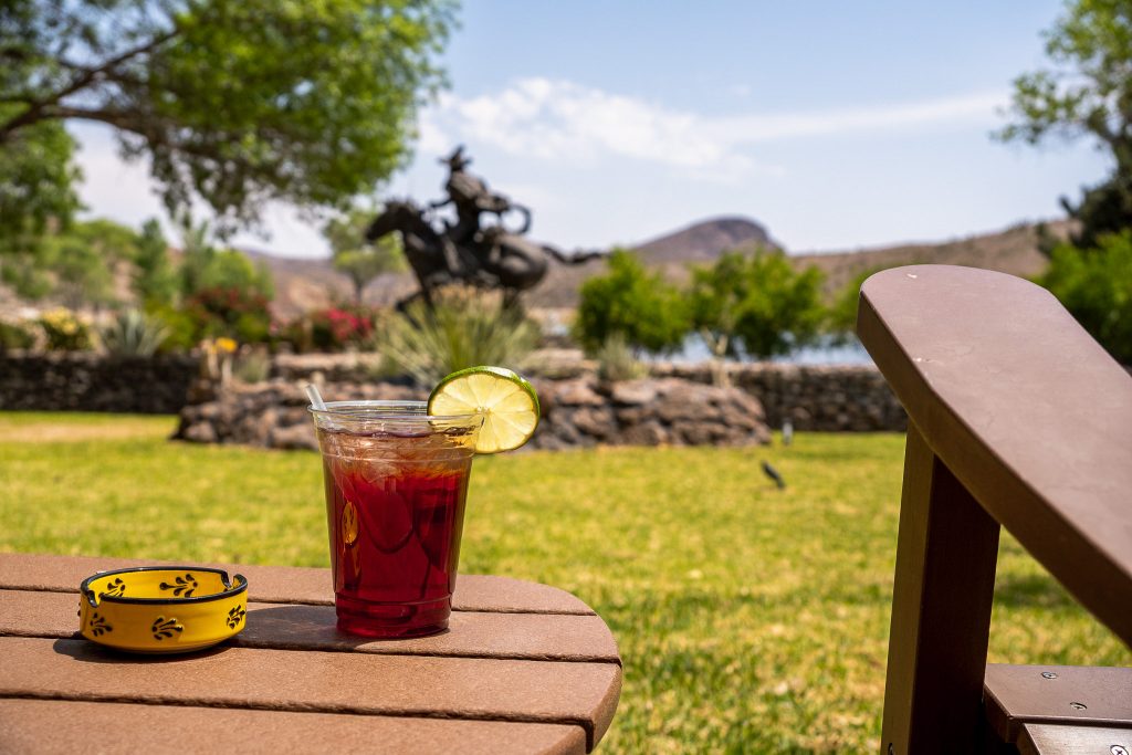 Relaxing outdoor scene at Cibolo Creek Ranch with a refreshing drink on a sunny day.